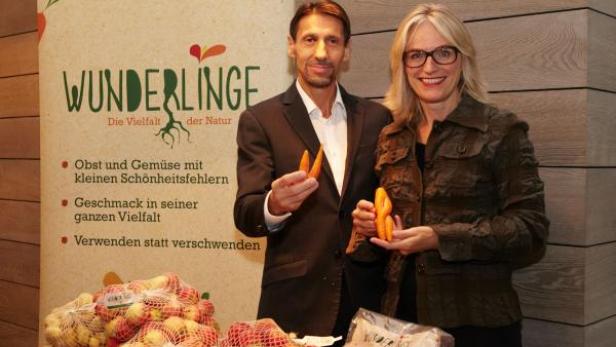 Zwei Personen präsentieren „Wunderlinge“, Obst und Gemüse mit kleinen Schönheitsfehlern.