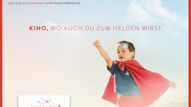 Ein Junge mit Superhelden-Umhang und -Maske steht vor einem hellen Himmel.