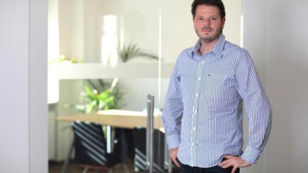 Ein Mann mit gestreiftem Hemd steht in einem Büro.