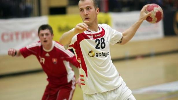 Ein Handballspieler mit der Nummer 28 wirft den Ball.