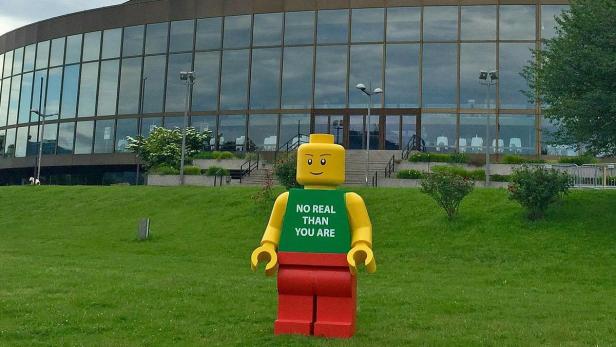 Ein rund zwei Meter großer Lego-Mann mit der Aufschrift &quot;No real than you are&quot; steht vor dem Brucknerhaus in Linz.
