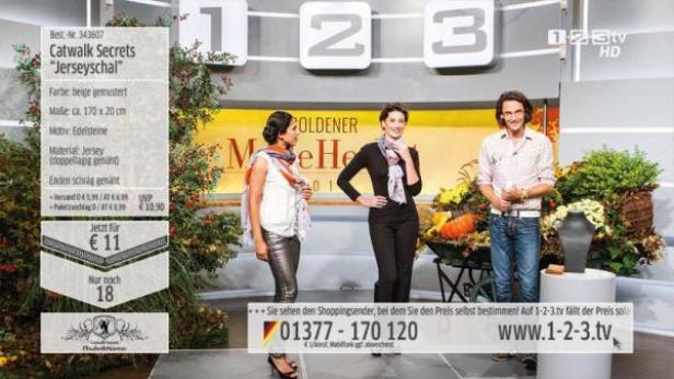 Drei Personen präsentieren auf einer Bühne den „Catwalk Secrets“-Jerseyschal.