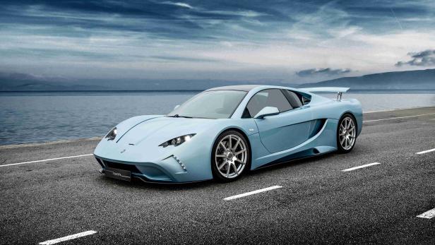 Ein hellblaues Vencer-Sportauto steht auf einer Küstenstraße.