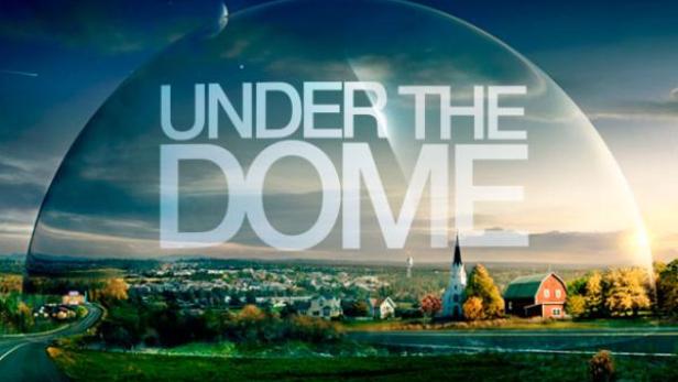 Das Logo der Fernsehserie „Under the Dome“ über einer amerikanischen Kleinstadt unter einer Kuppel.