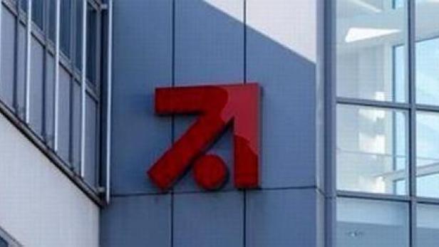 Das rote Logo von ProSiebenSat.1 an einem modernen Bürogebäude.