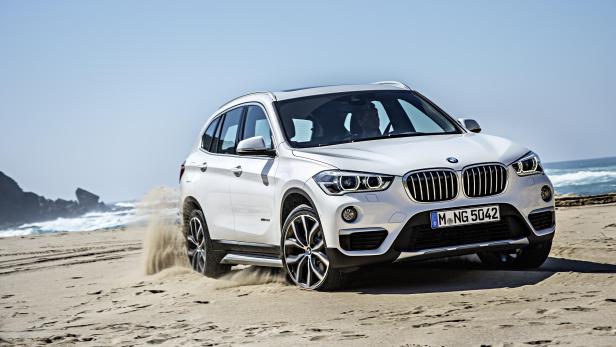 Ein weißer BMW X1 fährt am Strand entlang.