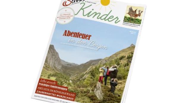 Das Cover des „Servus Kinder“-Magazins zeigt eine Gruppe von Menschen in den Bergen.