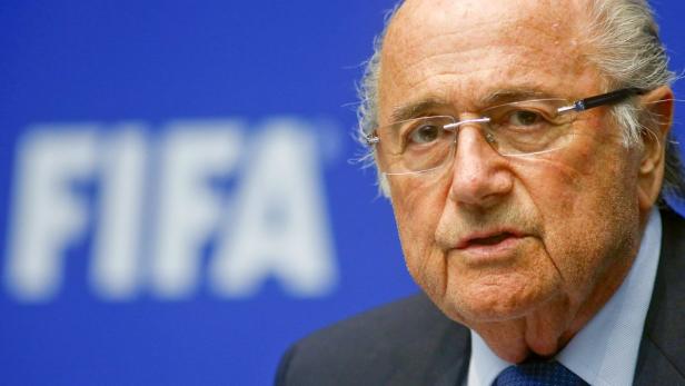 Sepp Blatter vor einem blauen FIFA-Hintergrund.
