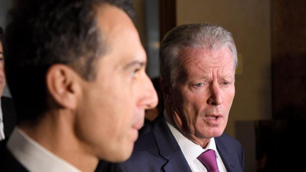 Zwei Männer in Anzügen unterhalten sich.