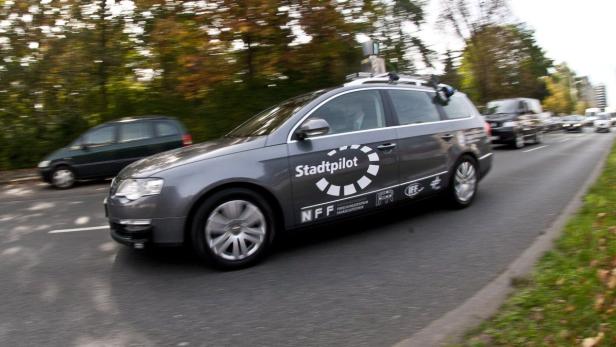 Ein grauer „Stadtpilot“-Wagen fährt auf einer Straße.