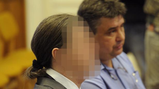 Eine Frau mit verpixeltem Gesicht und ein Mann sitzen nebeneinander.