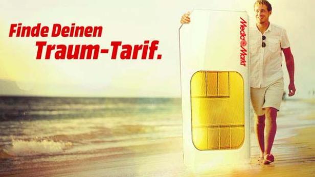 Ein Mann geht am Strand und hält eine übergroße SIM-Karte von Media Markt.