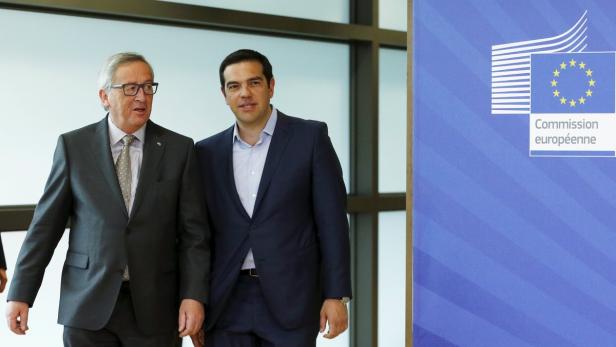 Jean-Claude Juncker und Alexis Tsipras posieren vor einem Banner der Europäischen Kommission.