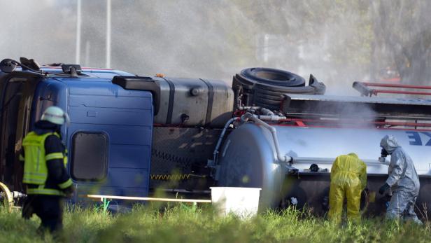 Ein umgekippter Tanklastwagen wird von Einsatzkräften in Schutzanzügen untersucht.