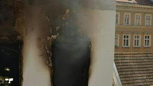 Ein durch ein Feuer beschädigter Pfeiler vor einem Gebäude.