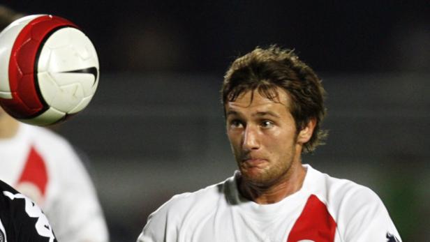 Ein Fußballspieler mit einem Ball in der Luft.
