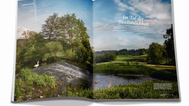 Eine Doppelseite einer Zeitschrift zeigt eine Landschaft mit einem Fluss und einem Schwan.