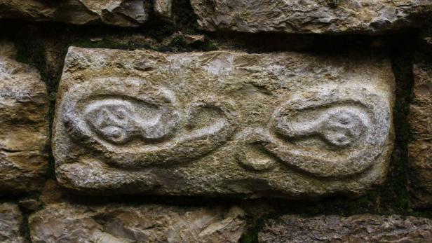 Figures representing snakes are seen on a wall of the Kuelap Fortress, 3000 meters (9840 feet) above sea level, in the Andean region of Chachapollas January 30, 2009. The archaeological site of Kuelap, constructed by the Chachapollas pre-Inca culture in about 800 AD, is a massive exterior of stone walls that rise up to 19 meters (62 feet) and contains more than four hundred buildings. Picture taken January 30, 2009. REUTERS/Pilar Olivares (PERU)