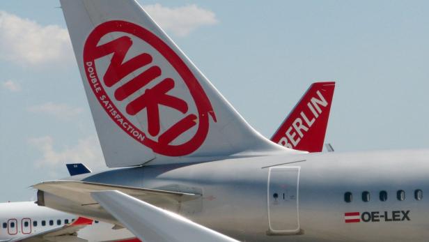 Das Heck einer Niki-Maschine mit dem roten Logo „NIKI DOUBLE SATISFACTION“ und einer Air-Berlin-Maschine im Hintergrund.