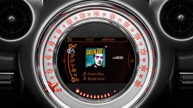 Das Armaturenbrett eines Mini Cooper zeigt das Album „Brutal Love“ von Green Day auf Deezer.