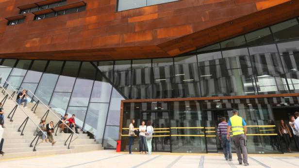 Menschen vor dem Haupteingang der Wirtschaftsuniversität Wien.