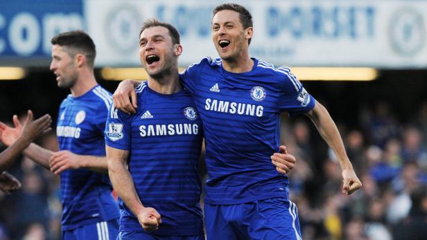 Zwei jubelnde Fußballspieler des FC Chelsea in blauen Trikots umarmen sich.