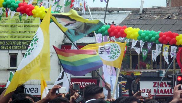 Eine Menschenmenge demonstriert mit HDP-Flaggen und Regenbogenfahnen.