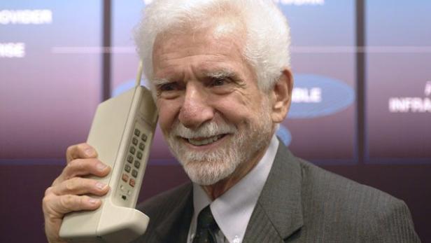 Martin Cooper hält das erste Mobiltelefon, das Motorola DynaTAC 8000x, ans Ohr.