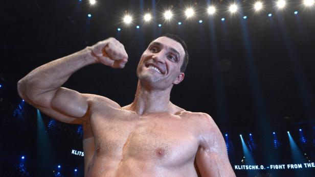 Wladimir Klitschko jubelt mit geballter Faust unter dem Scheinwerferlicht.