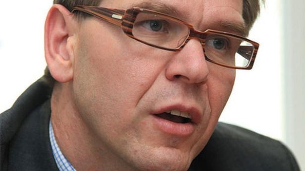 Ein Mann mit Brille spricht.