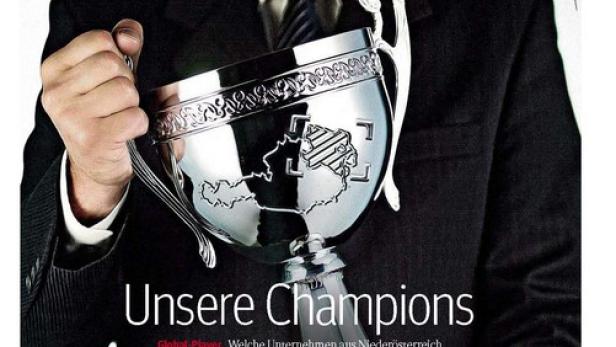 Ein Mann im Anzug hält einen silbernen Pokal mit der Karte von Niederösterreich.