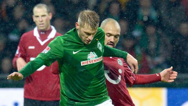 Zwei Fußballspieler im Zweikampf auf dem Spielfeld.