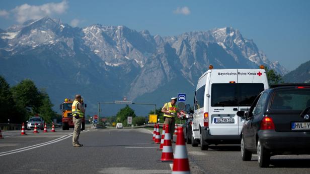 Polizisten kontrollieren den Verkehr vor einer Bergkulisse.