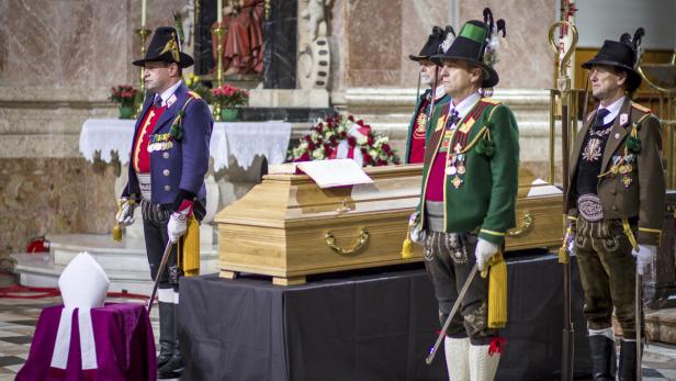 Schützen stehen Ehrenwache an einem Sarg in einer Kirche.