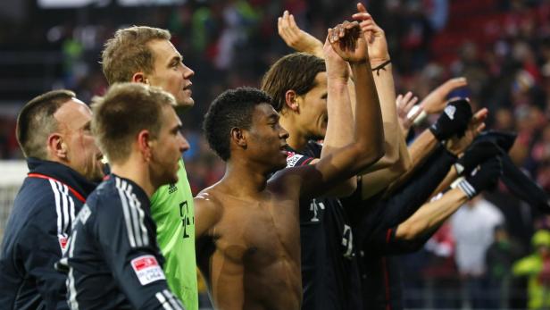 Spieler des FC Bayern München jubeln mit erhobenen Armen.