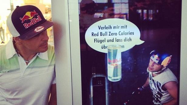 Ein Mann betrachtet eine Red Bull Zero Calories Werbung an einem Automaten.