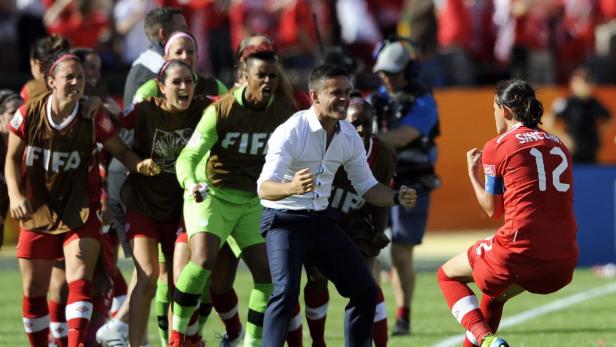 Das kanadische Frauenfußballteam und sein Trainer feiern einen Sieg.