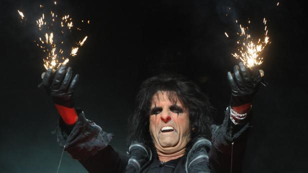 Alice Cooper hält während eines Auftritts Wunderkerzen in die Luft.