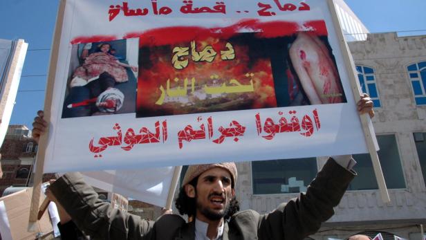 Ein Demonstrant ruft auf seinem Plakat gegen die Gewalt der Houthi-Rebellen auf.
