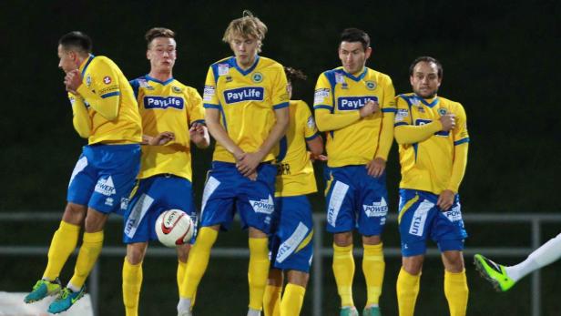Eine Gruppe von Fußballspielern in gelb-blauen Trikots steht auf dem Spielfeld.