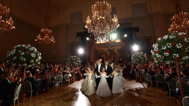 Junge Debütantinnen und ihre Partner eröffnen einen festlichen Ballsaal.