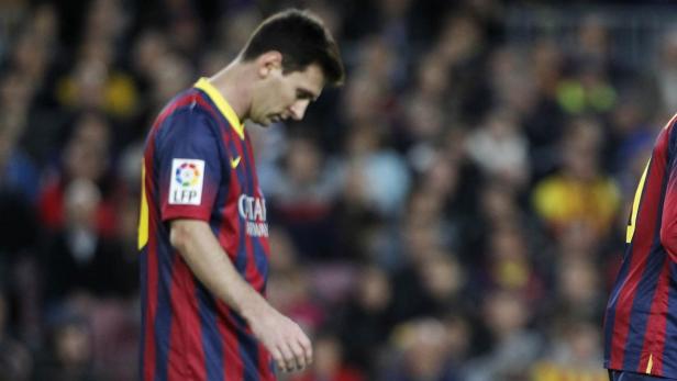 Lionel Messi in einem blau-rot gestreiften Trikot senkt den Kopf.