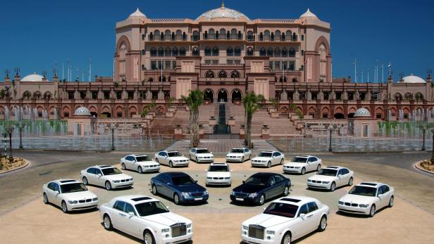Mehrere Luxusautos stehen vor dem Emirates Palace Hotel in Abu Dhabi.