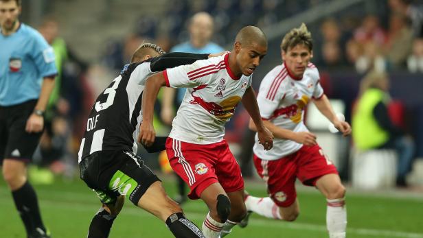 Ein Fußballspieler im rot-weißen Trikot von Red Bull Salzburg im Zweikampf.