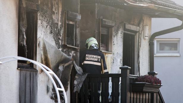 Ein Feuerwehrmann beim Eingang des ausgebrannten Gebäudes.