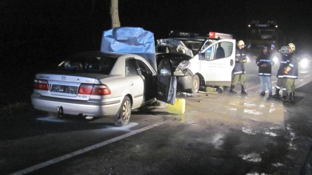 Ein Autounfall bei Nacht mit Feuerwehrleuten am Unfallort.