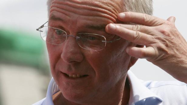Ein Mann mit Brille berührt seine Stirn.