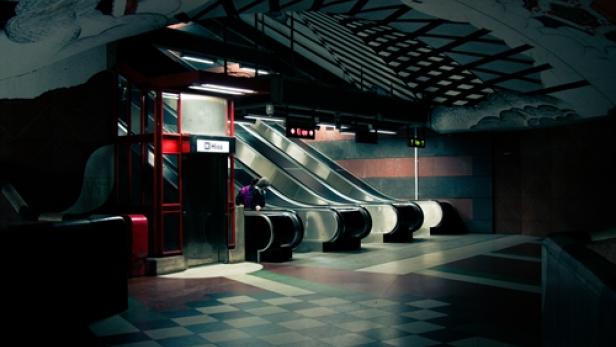 Eine Person fährt auf einer Rolltreppe in einer U-Bahn-Station.