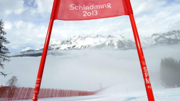 Blick durch ein rotes Tor auf die verschneiten Berge von Schladming 2013.