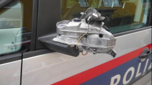 Ein beschädigter Außenspiegel an einem Polizeiauto.